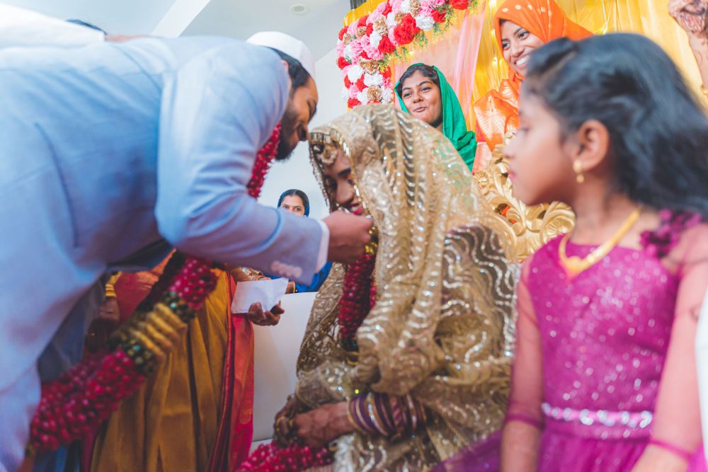 Traditional ceremony moment with gold and pink decor and participants in formal attire.