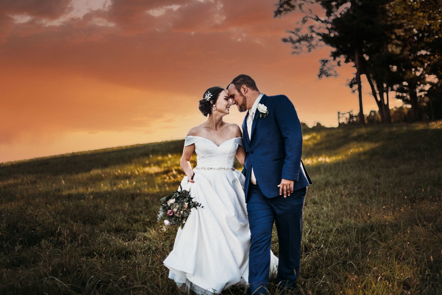 bride and groom share a snuggle in a field