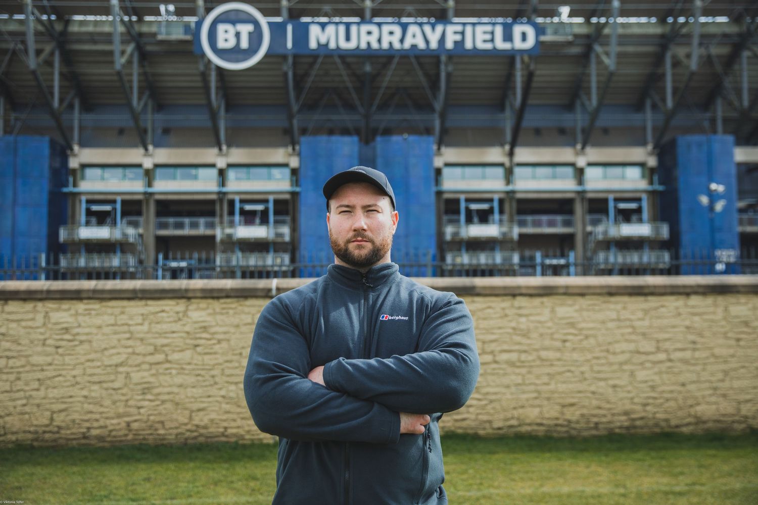 Empty sports stadium with Murrayfield signage and blue seating sections.