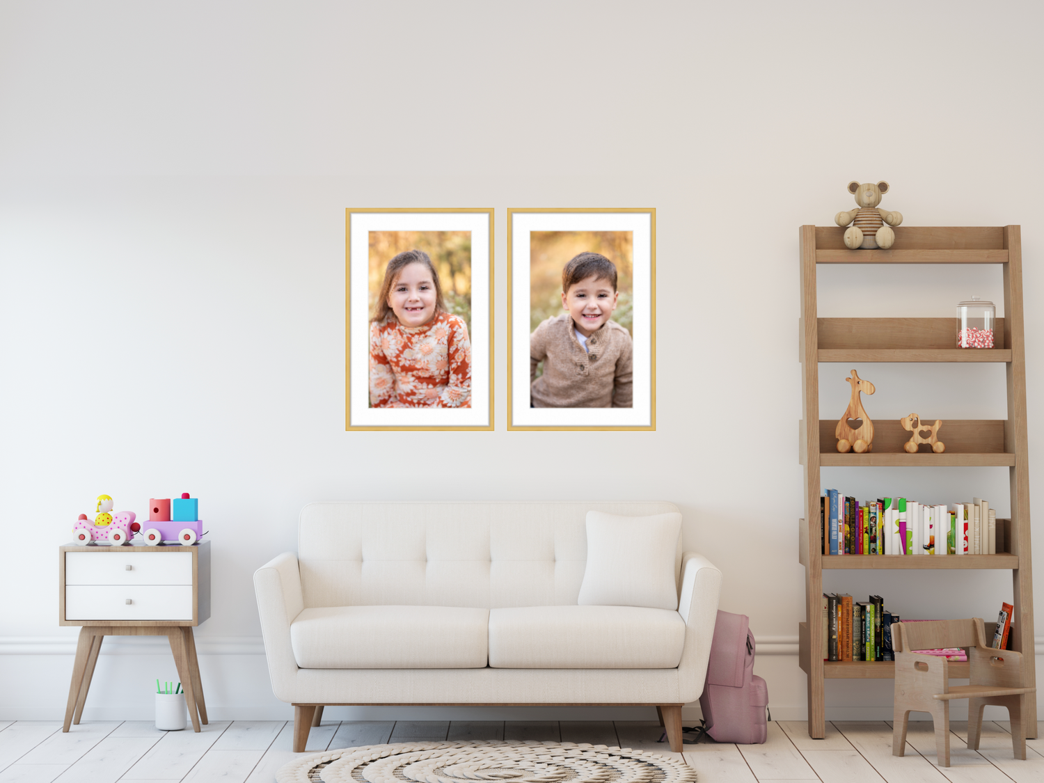 side-by-side portraits of young boy and girl hanging in on wall in playroom