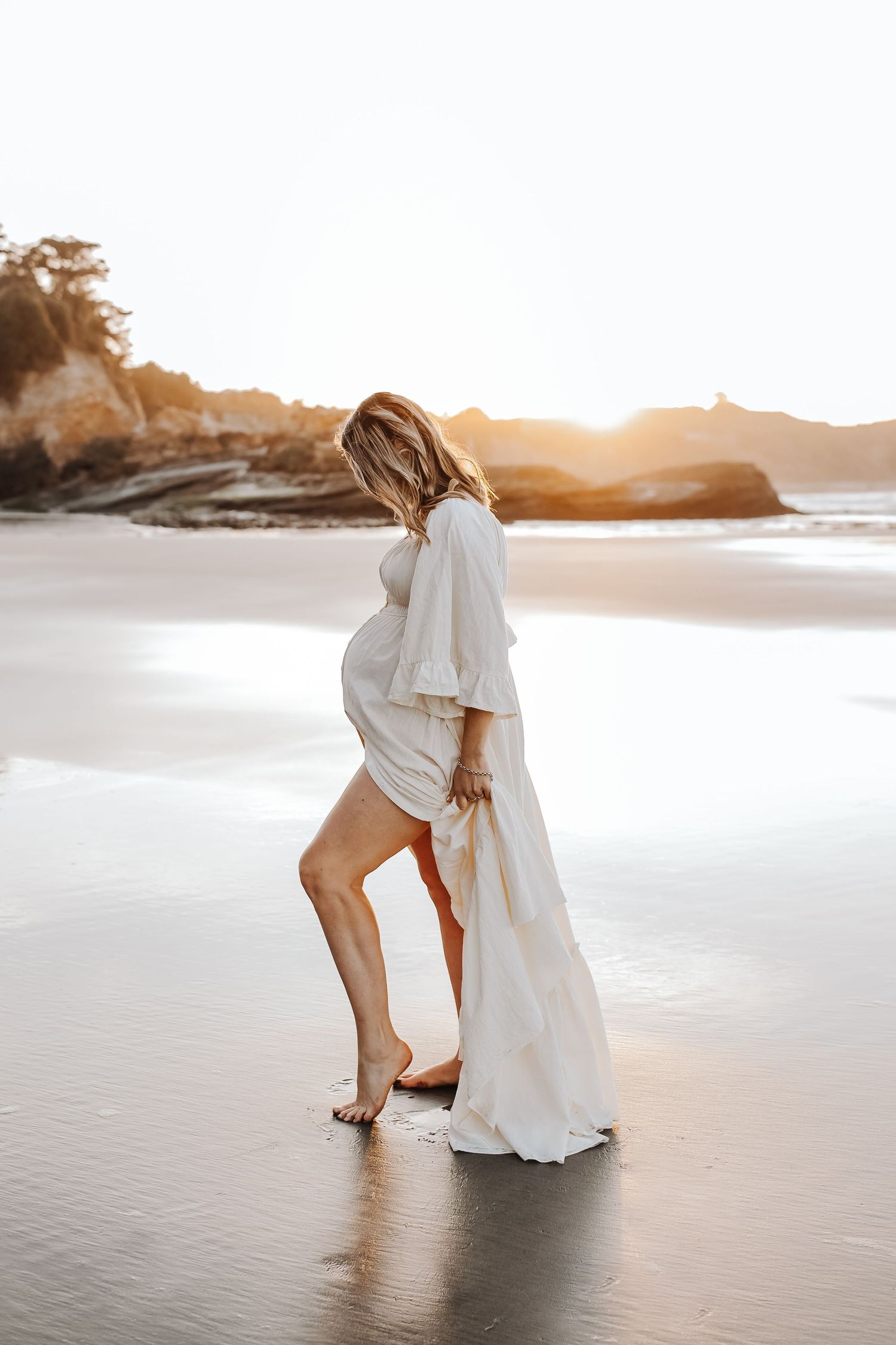 Maternity portrait of expectant mother on golden-hour beach Westport NZ