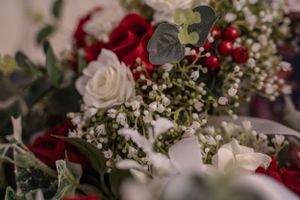 Elegant wedding floral arrangement featuring red and white roses with delicate baby's breath.