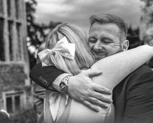 Black and white candid wedding portraits showing emotional embraces.