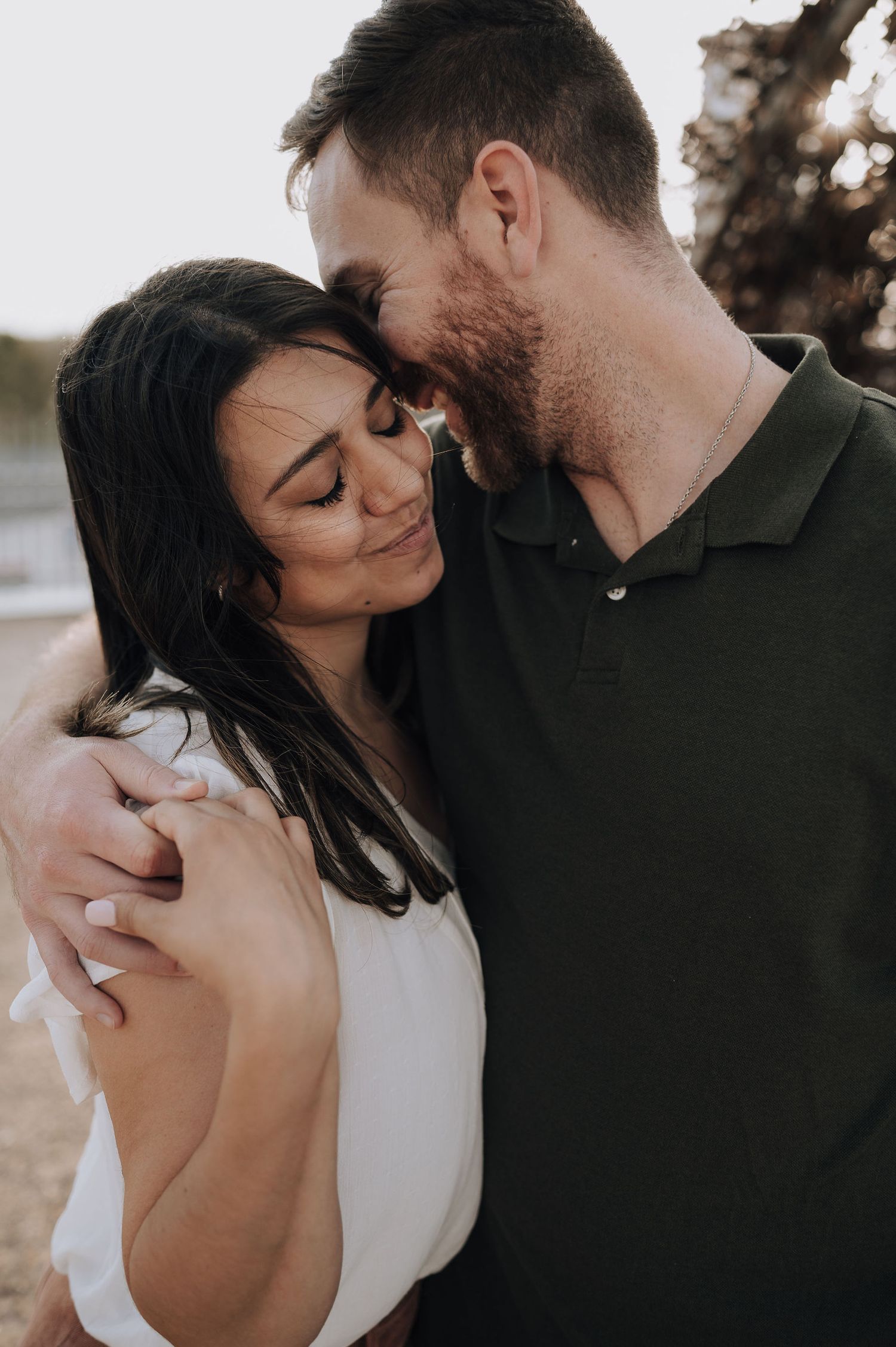 A loving couple sharing an intimate close-up moment outdoors during golden hour.
