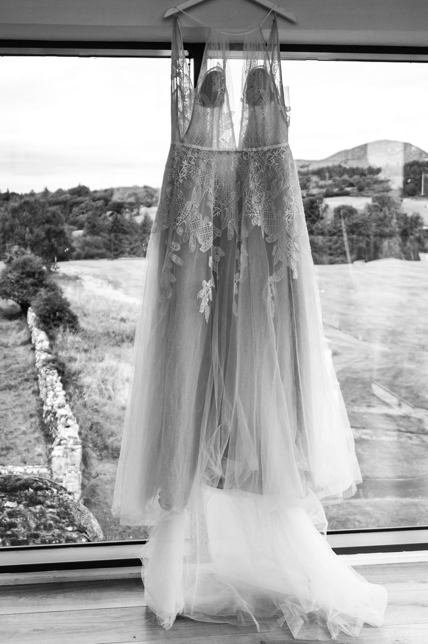wedding dress hanging in window black and white