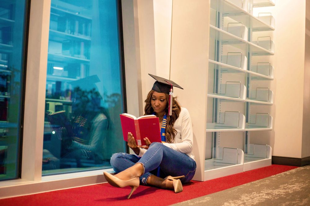 TSU student studies in library in graduation cap and heels in Houston, Texas.