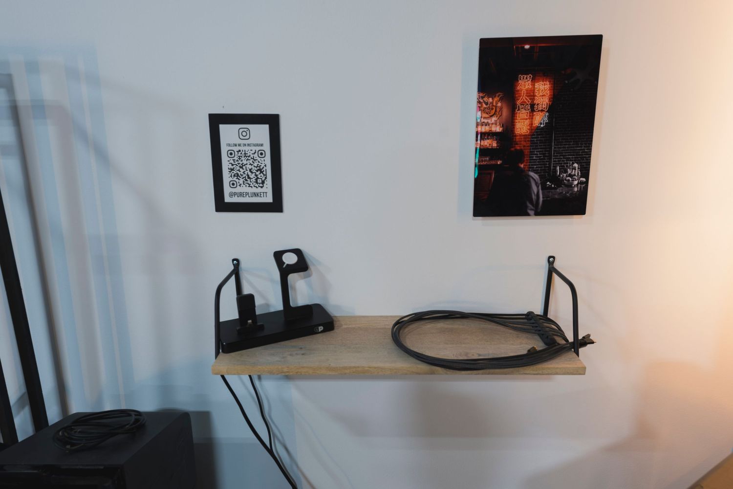 Minimalist wooden shelf mounted on wall with photography equipment.