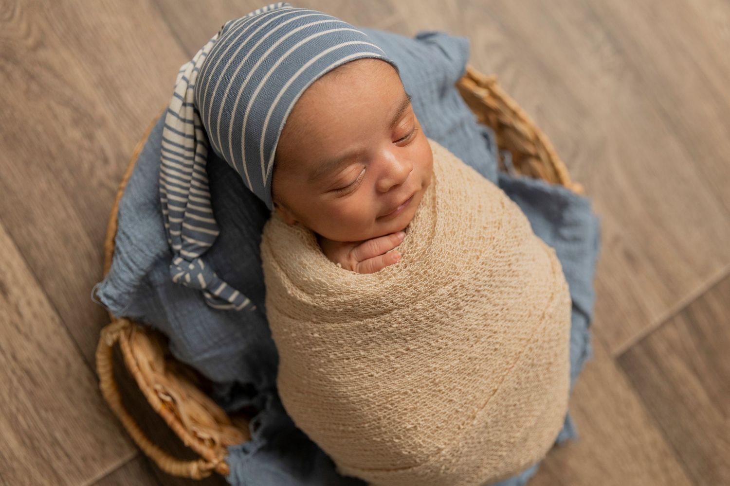 newborn baby boy wrapped in a beige wrap in potato by an Oakland county lifestyle photographer