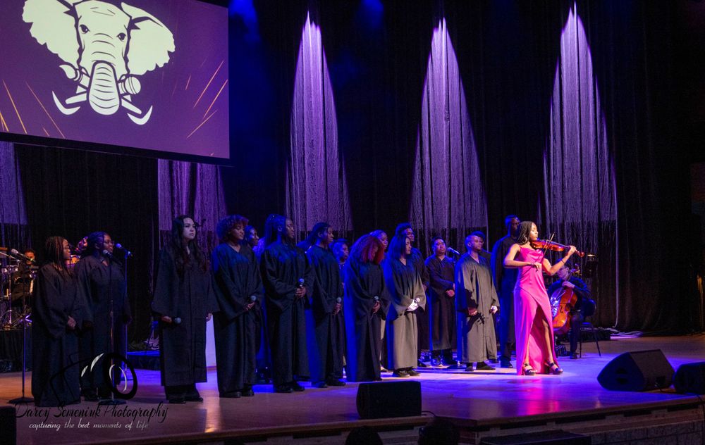A stage performance with purple lighting and theatrical curtains.