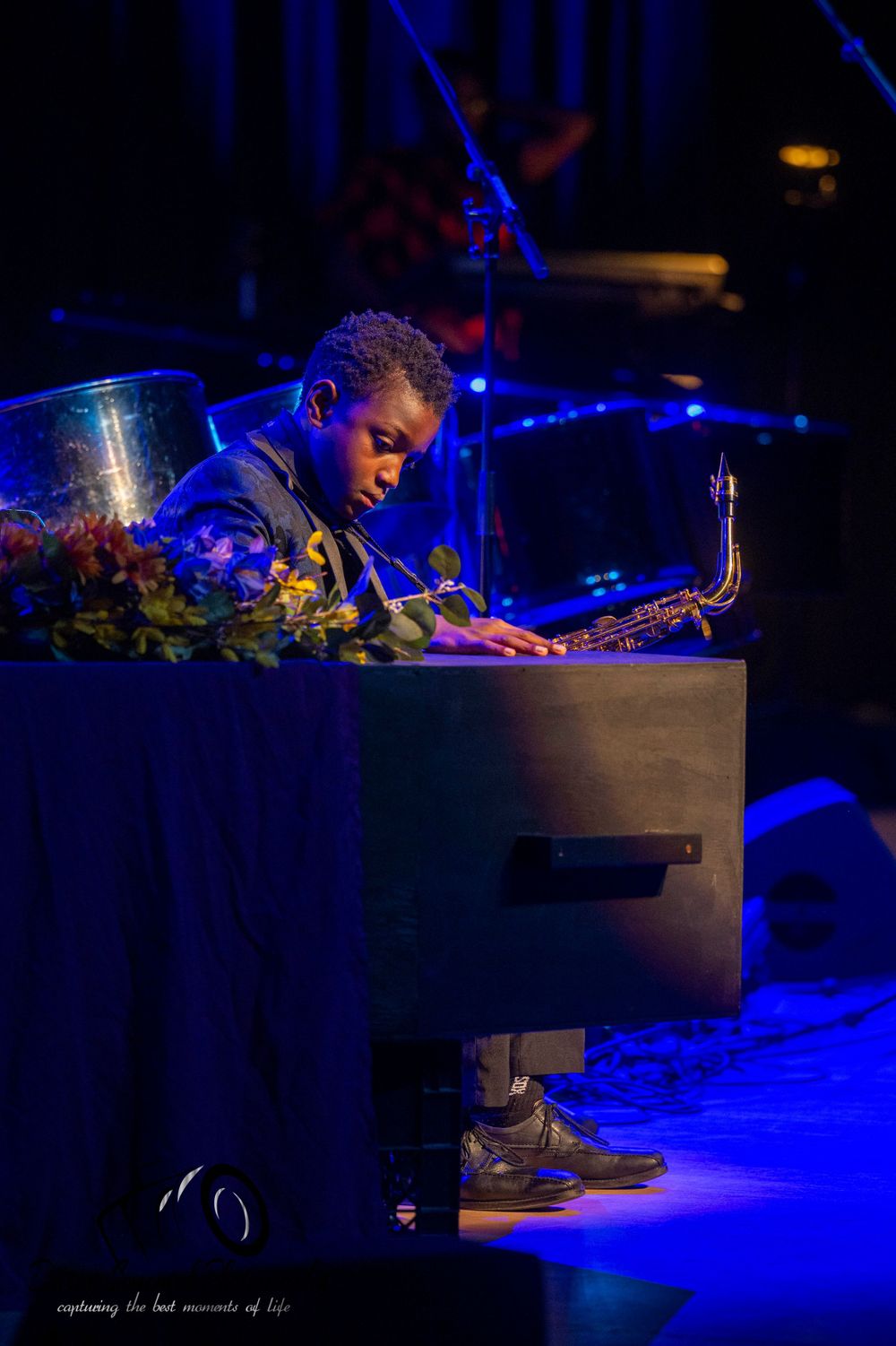 A musician performing on stage under dramatic blue lighting.