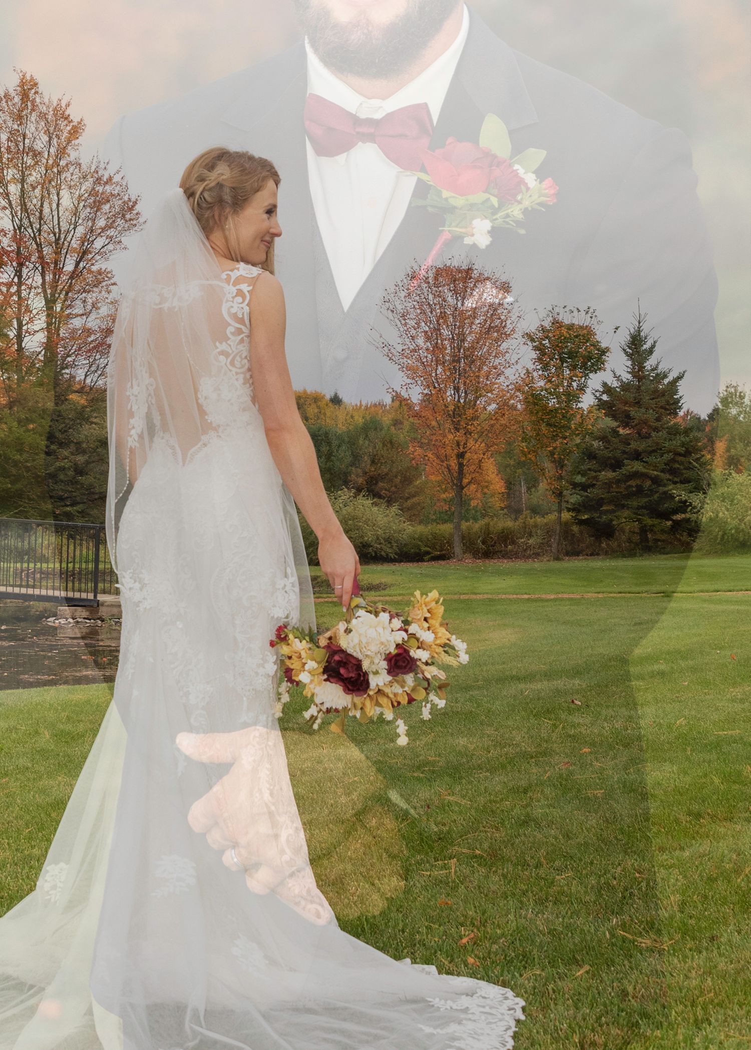 An elegant bridal gown with lace details photographed in an autumn field setting.