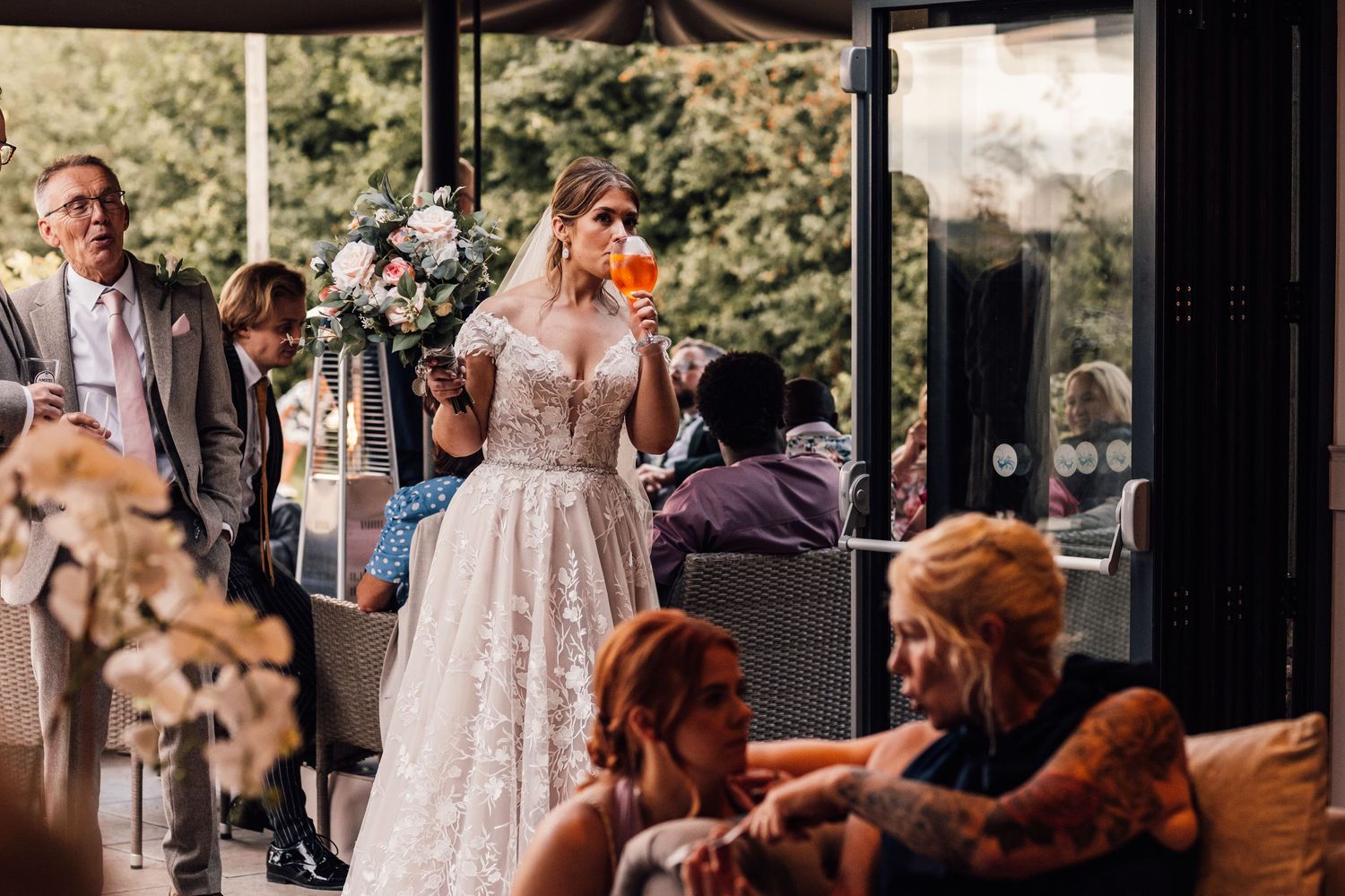 Wedding reception party with guests gathered in indoor-outdoor venue space.
