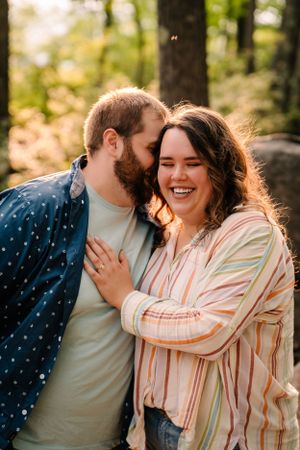 Candid laughter shared between couple during forest photography session.