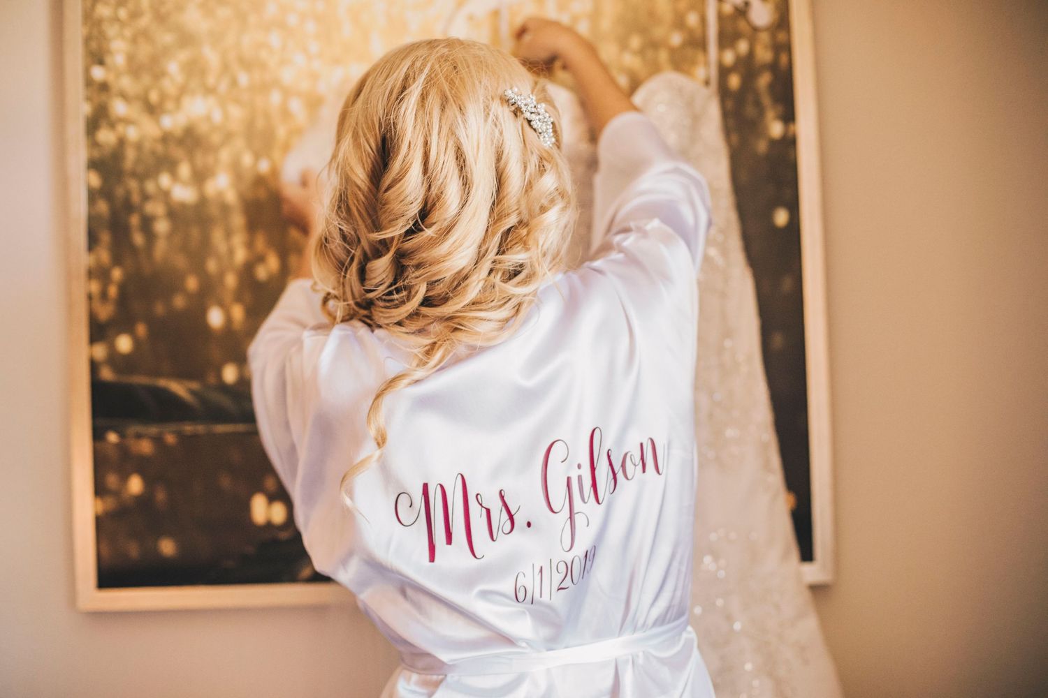 Bride in white robe personalized with Mrs. Gilson preparing for her wedding day.