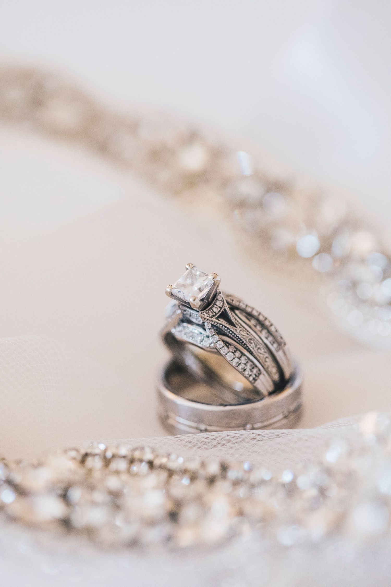 Elegant wedding ring set with diamond solitaire and band displayed on white fabric.