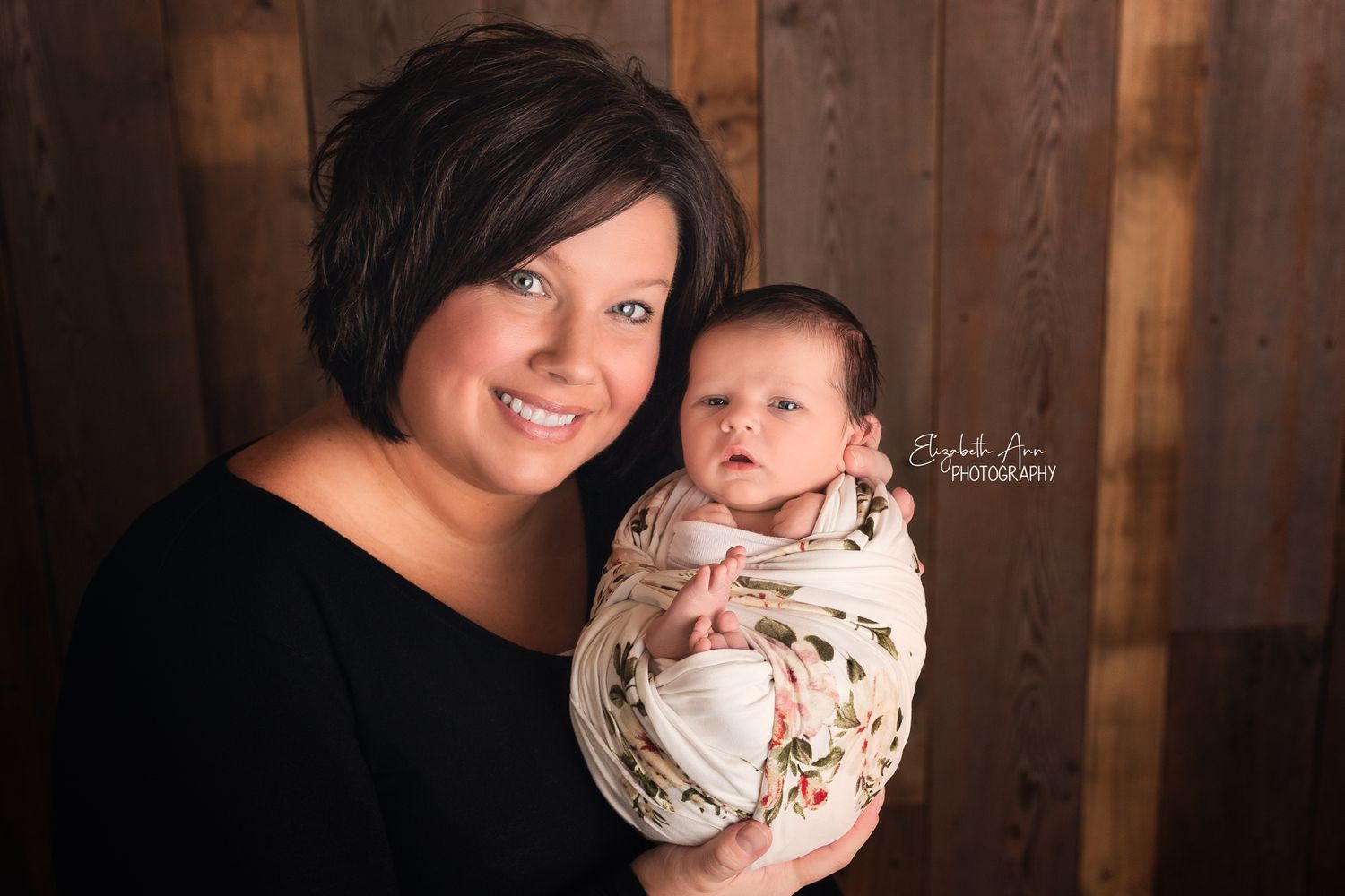 Beautiful mother holding her newborn daughter, floral wrap and barnwood backdrop; Elizabeth Ann Photography Wisconsin