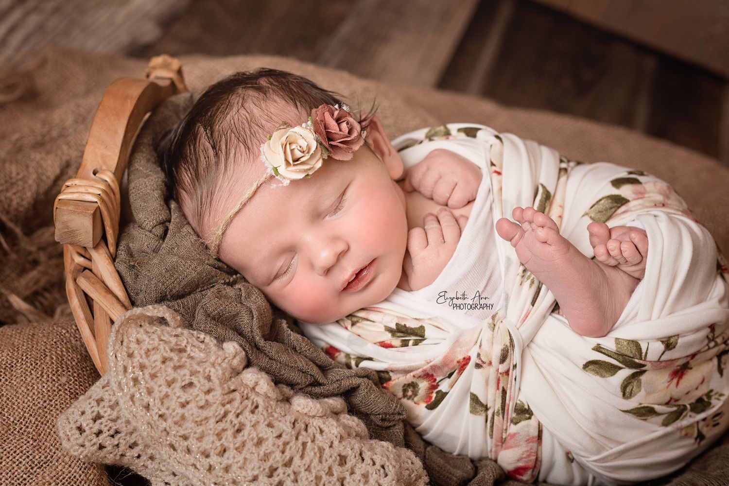 Beautiful newborn baby girl wearing a floral headband and wrap, asleep in a basket; Elizabeth Ann Photography Wisconsin