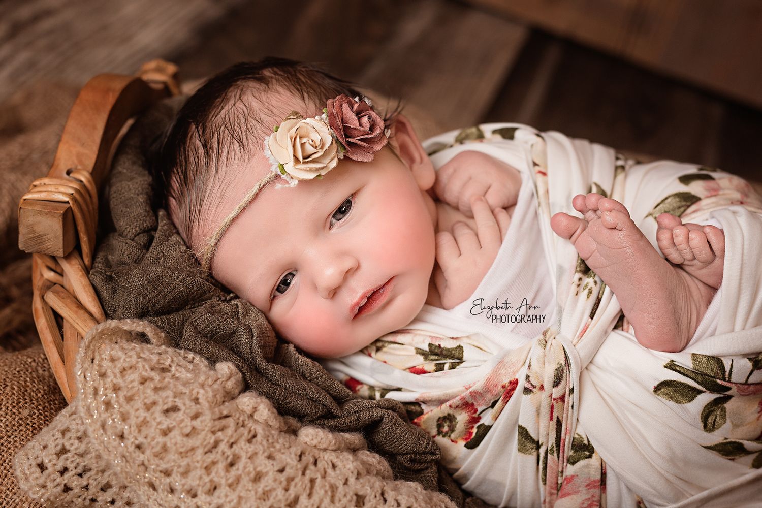 Beautiful newborn baby girl wearing a floral headband and wrap, eyes open; Elizabeth Ann Photography Wisconsin