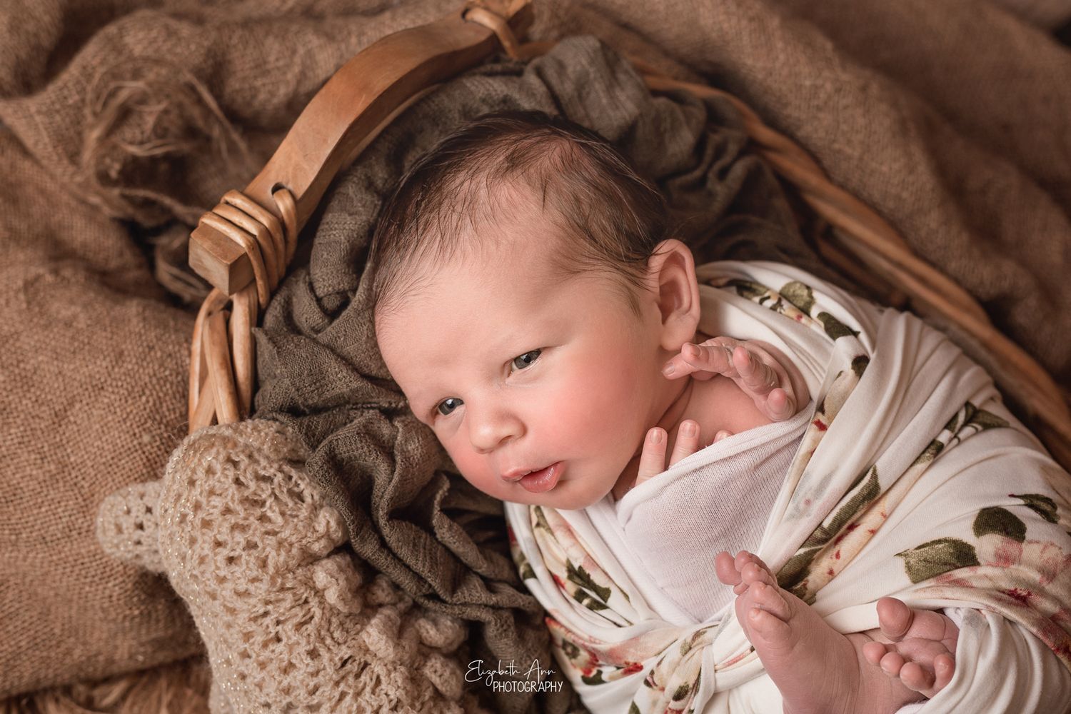 Beautiful newborn baby girl wearing a floral wrap, cute expression; Elizabeth Ann Photography Wisconsin