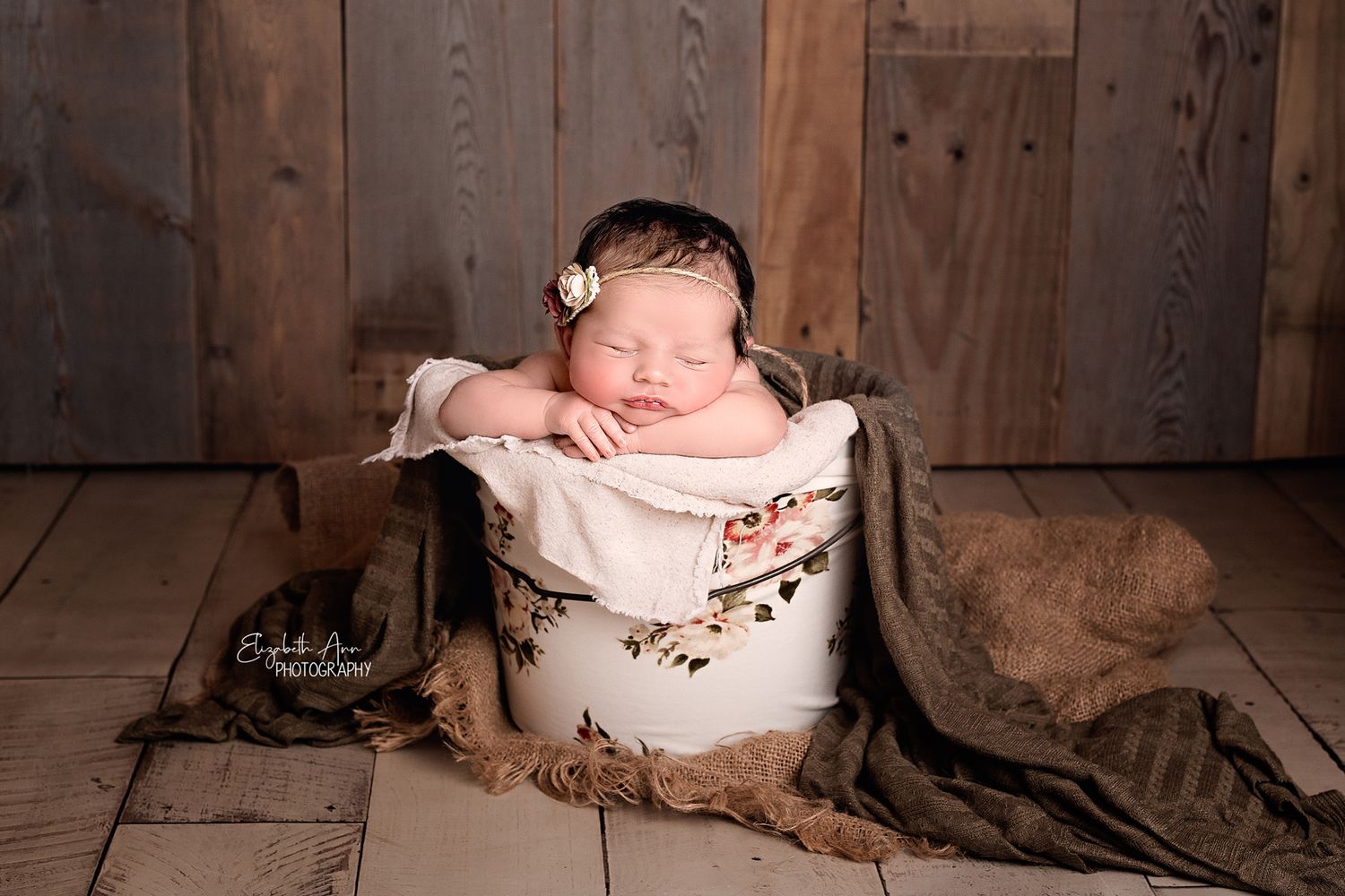 Beautiful newborn baby girl sleeping in a floral bucket with barn wood backdrop; Elizabeth Ann Photography Wisconsin