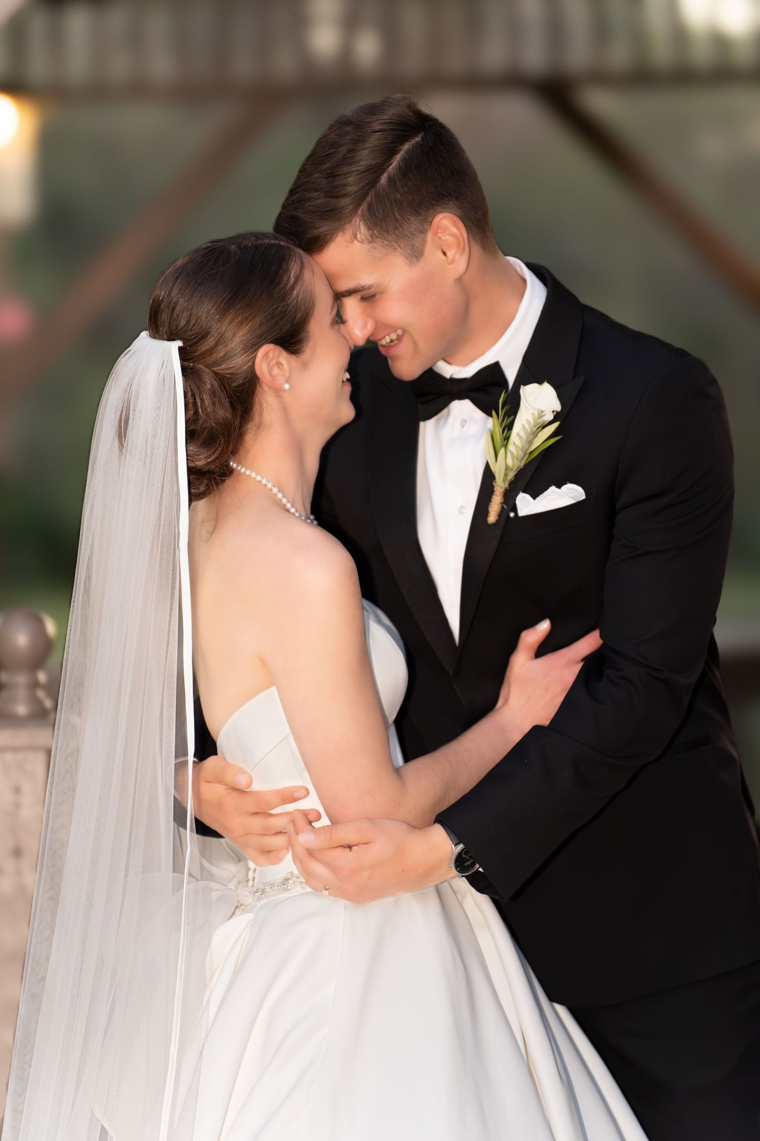 A tender moment between newlyweds as they embrace in formal wedding attire.
