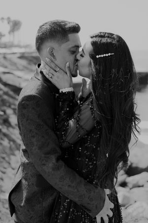 Black and white coastal photoshoot of couple in intimate embrace.