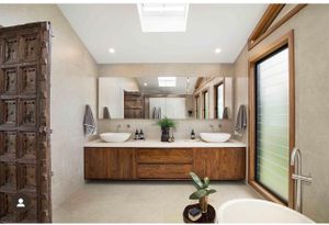 Modern bathroom featuring wooden vanity, vessel sinks and antique wooden door.