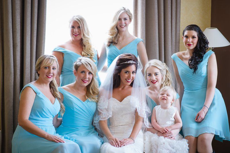 Bridesmaids in light blue dresses gathered together for a group photo.