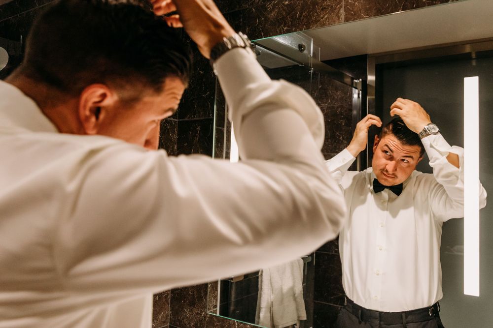 Person adjusting formal white dress shirt sleeves in black and white.