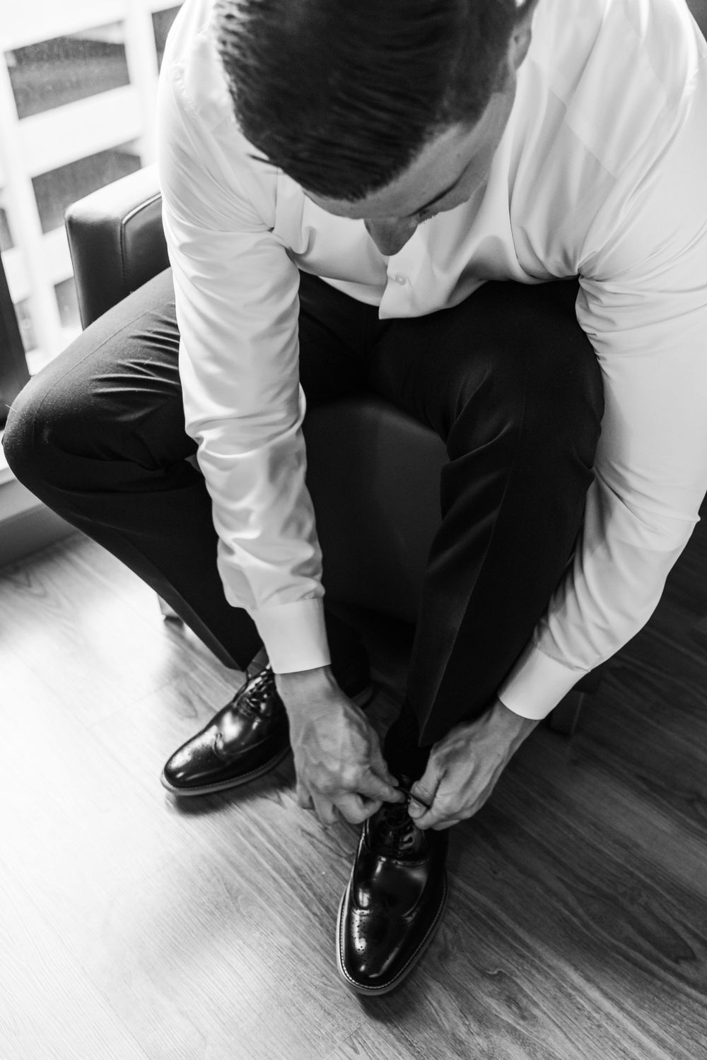 Close-up shots of person tying formal black dress shoes.