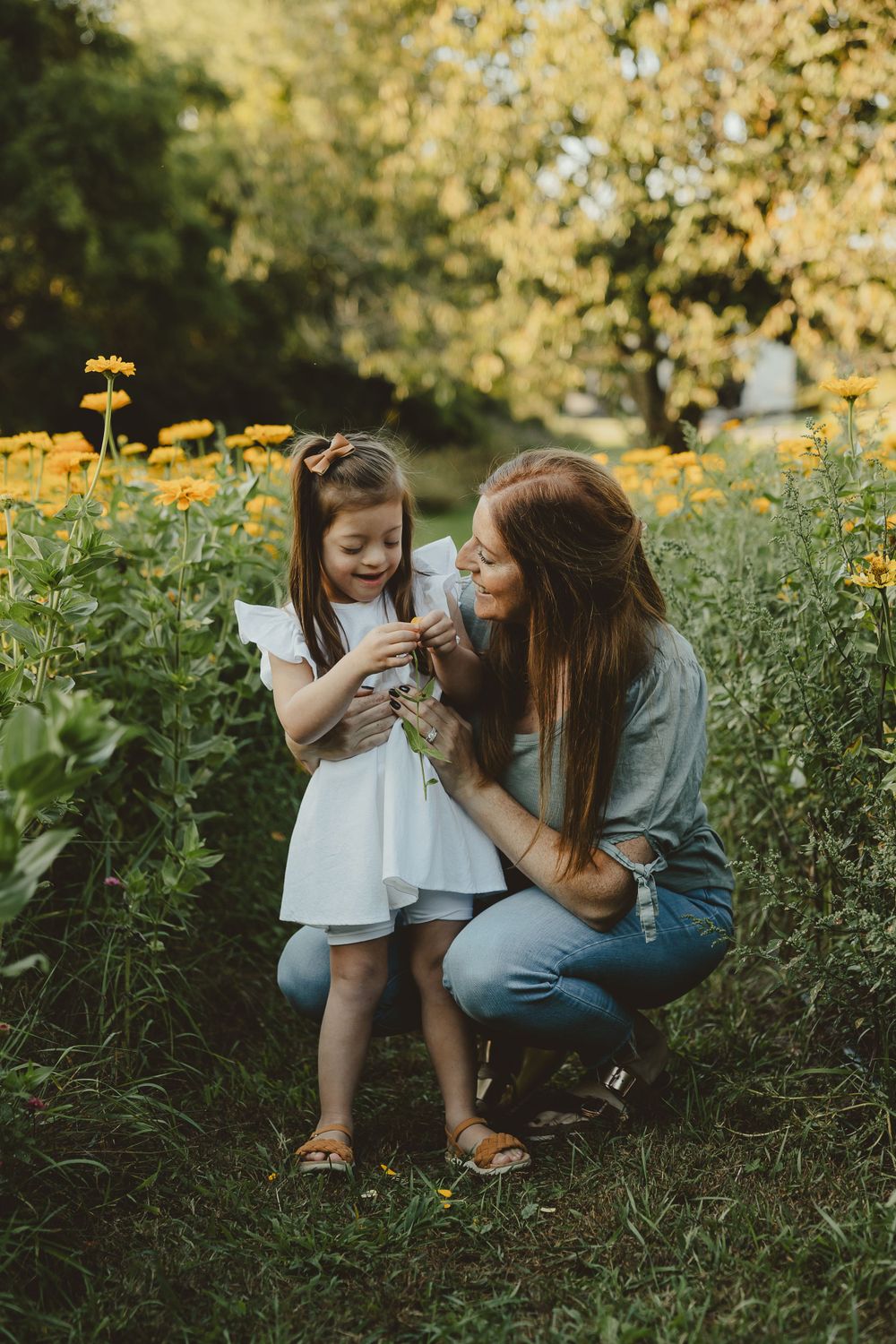 A tender moment shared among yellow wildflowers in a garden setting at sunset.
