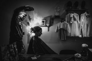 zwart-witte foto tijdens het klaarmaken van de bruid met haarspray