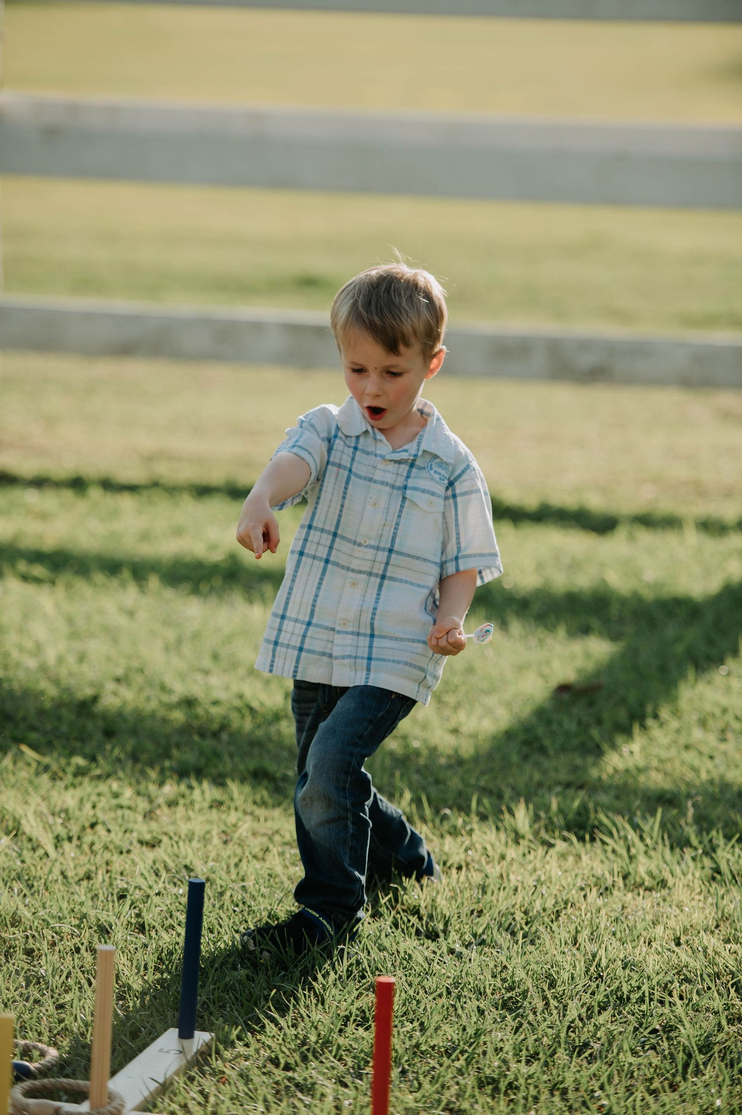 A young child walking carefully along a balance beam outdoors.