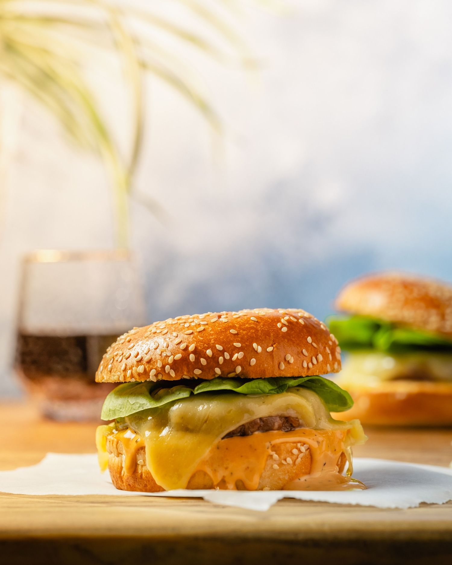 Staged cheeseburger with cheese oozing out on a table