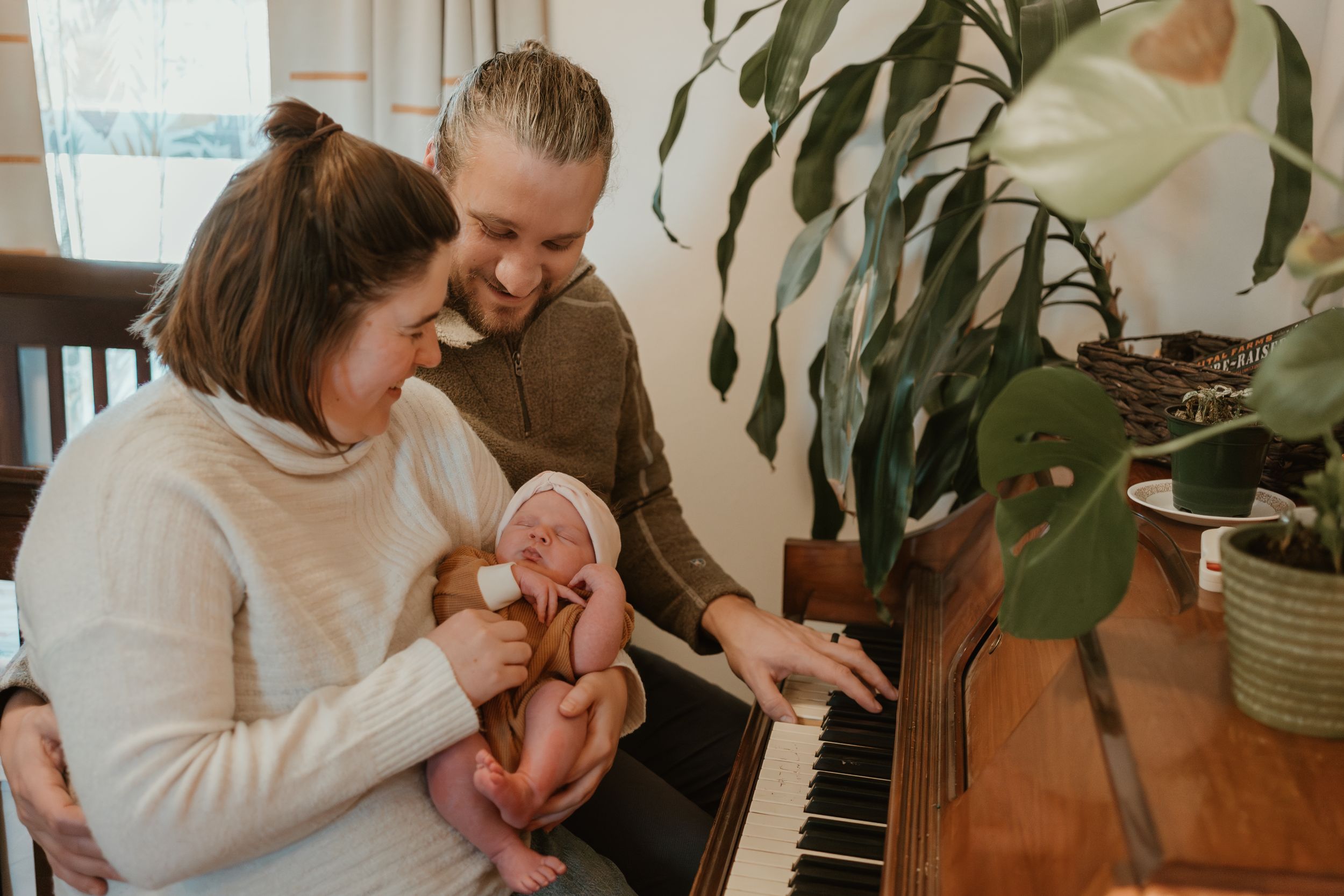 Couple sharing playful moment near indoor plants and piano.