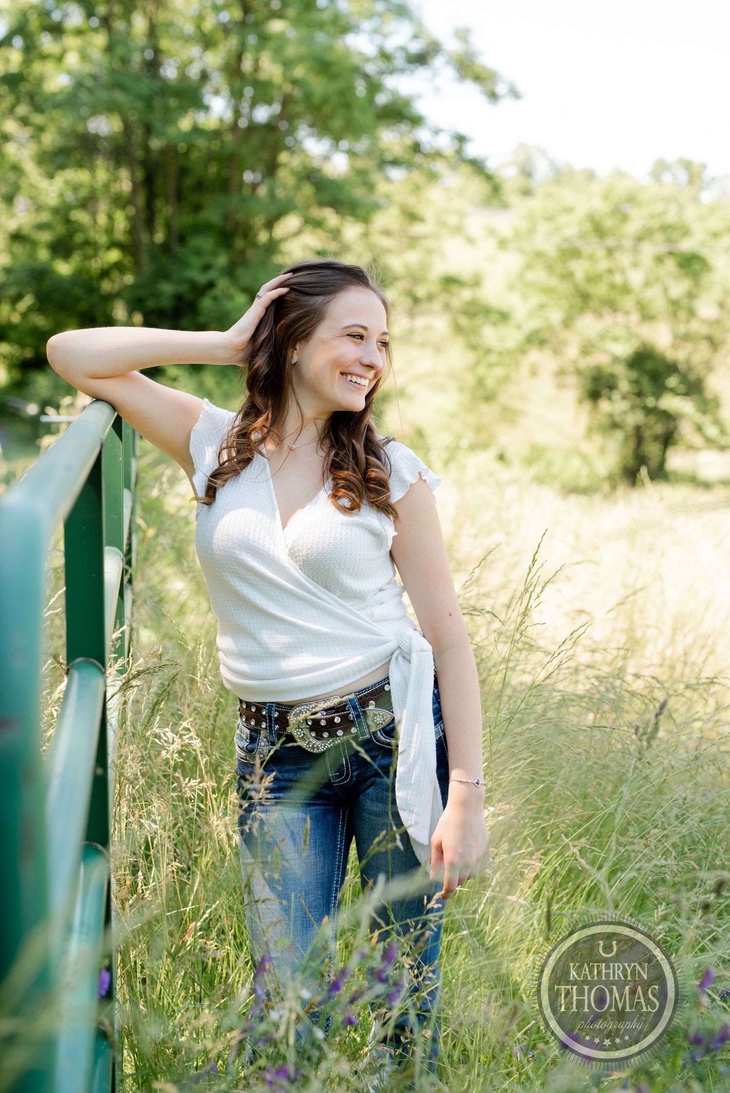 A candid moment captured by a green railing in a field with golden sunlight.