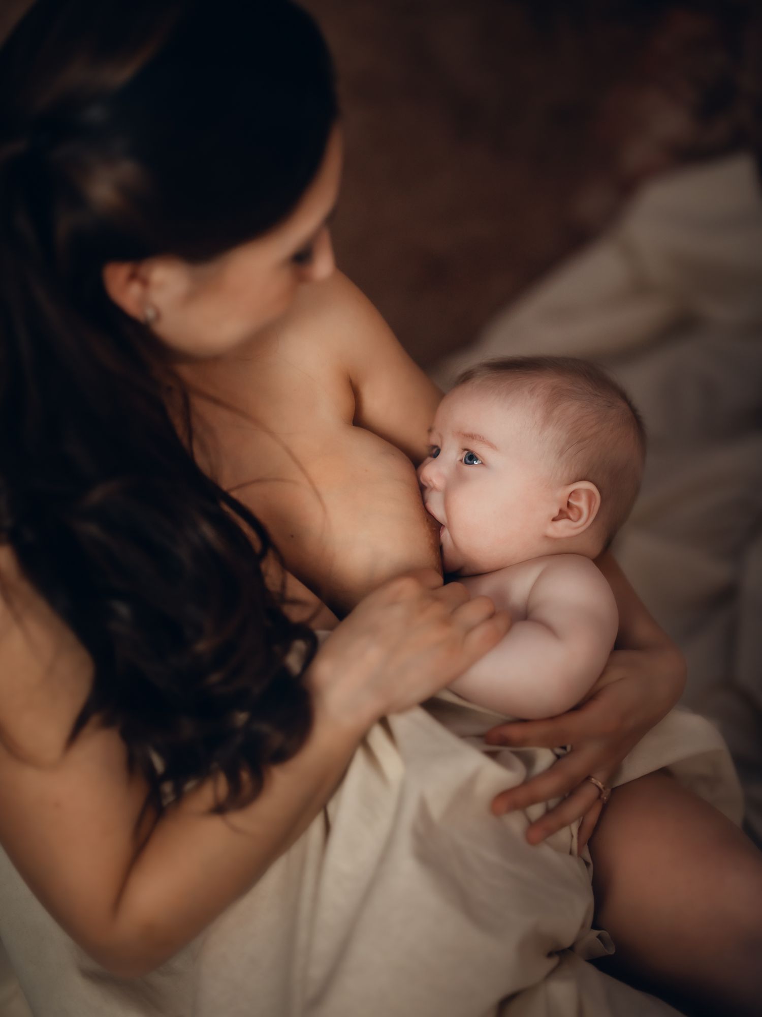 Mother kissing her baby in a tender, warm-toned portrait. Toronto motherhood photography.