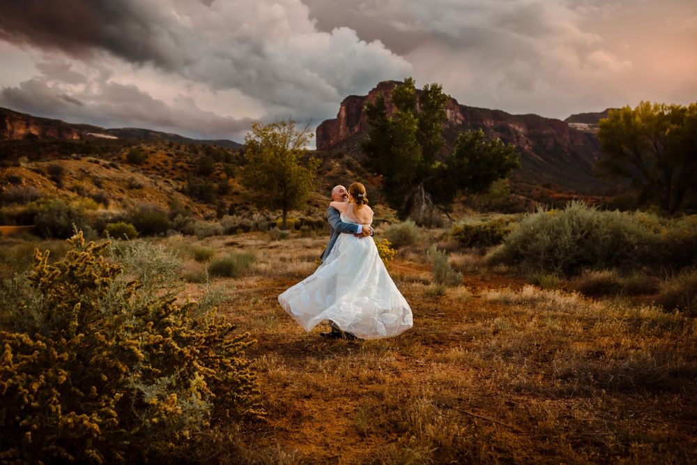 A bride and groom dance together in the Western Slope in Colorado as storm clouds fill the sky