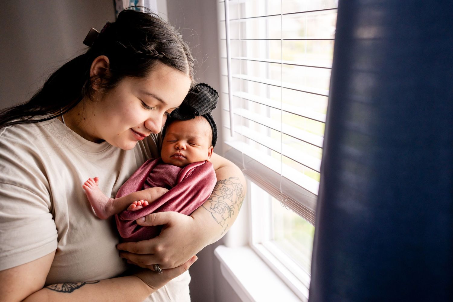 mom snuggling newborn daughter