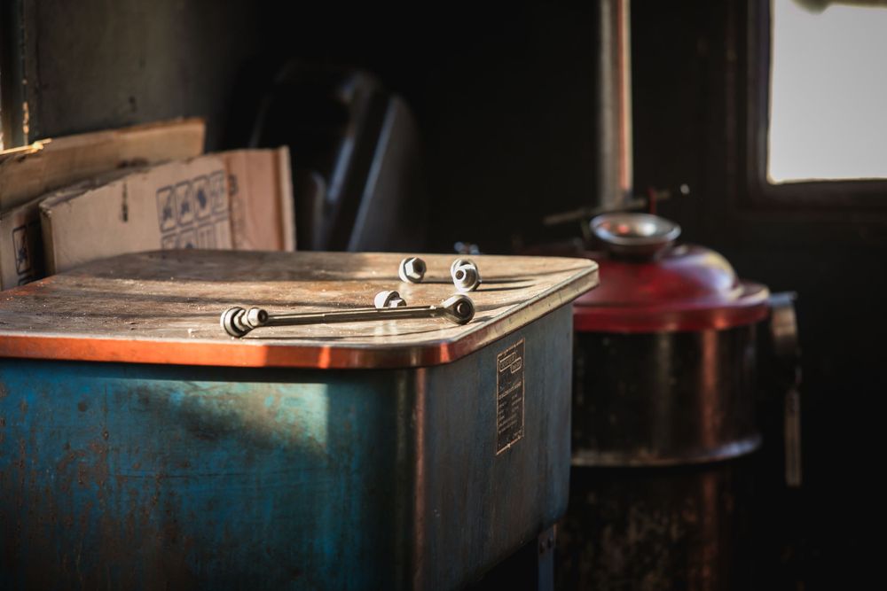 Close-up of rustic metal tools on a weathered blue surface in dim lighting.