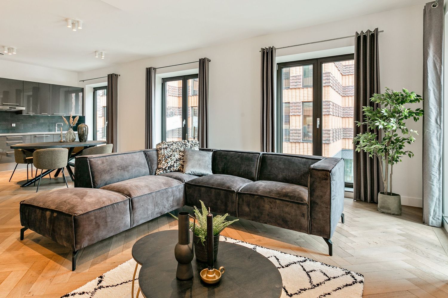 Modern gray corner sofa combined with blach two-piece coffee table set and ecru rug