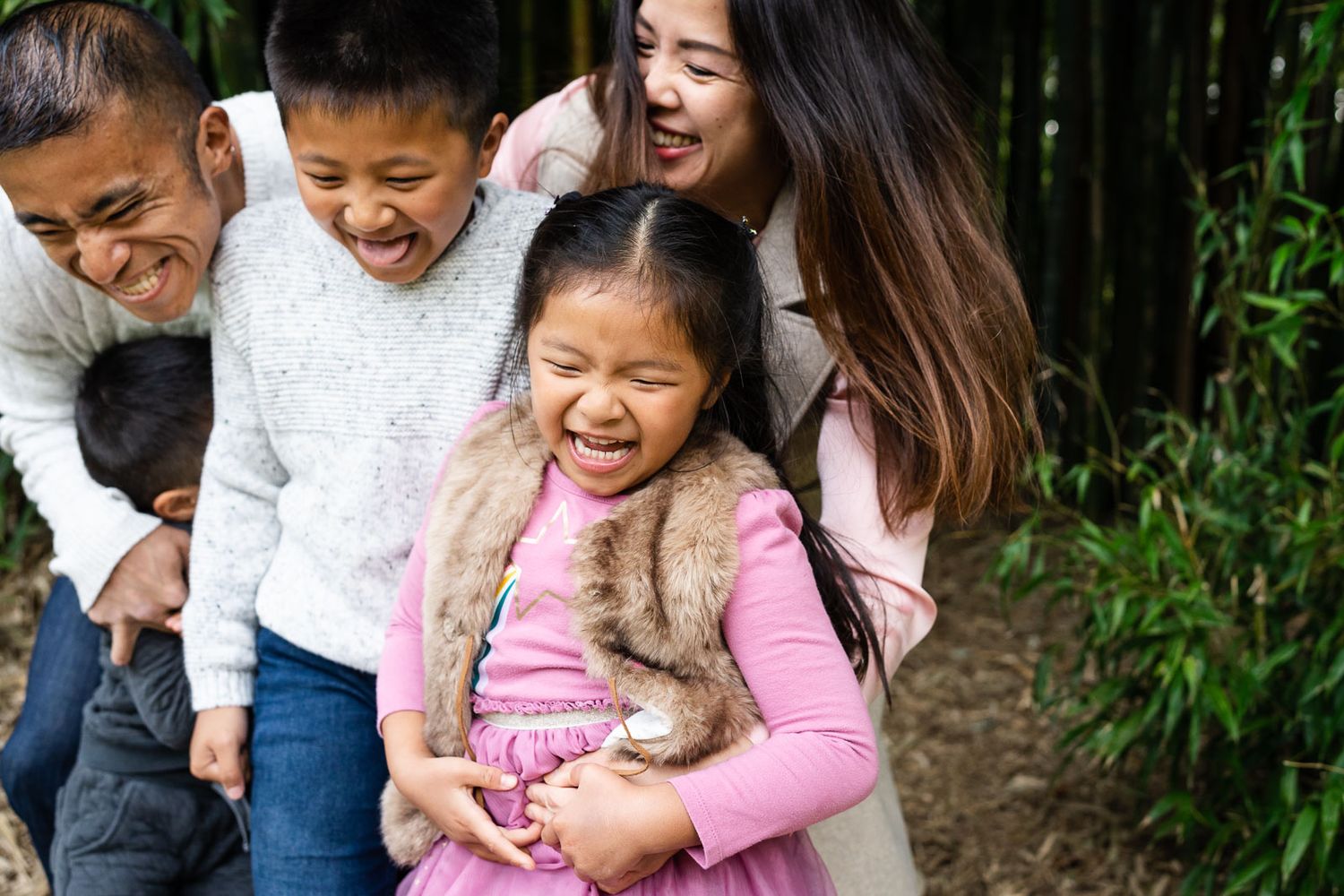 Bellevue family photographer capturing family tickling each other at the park