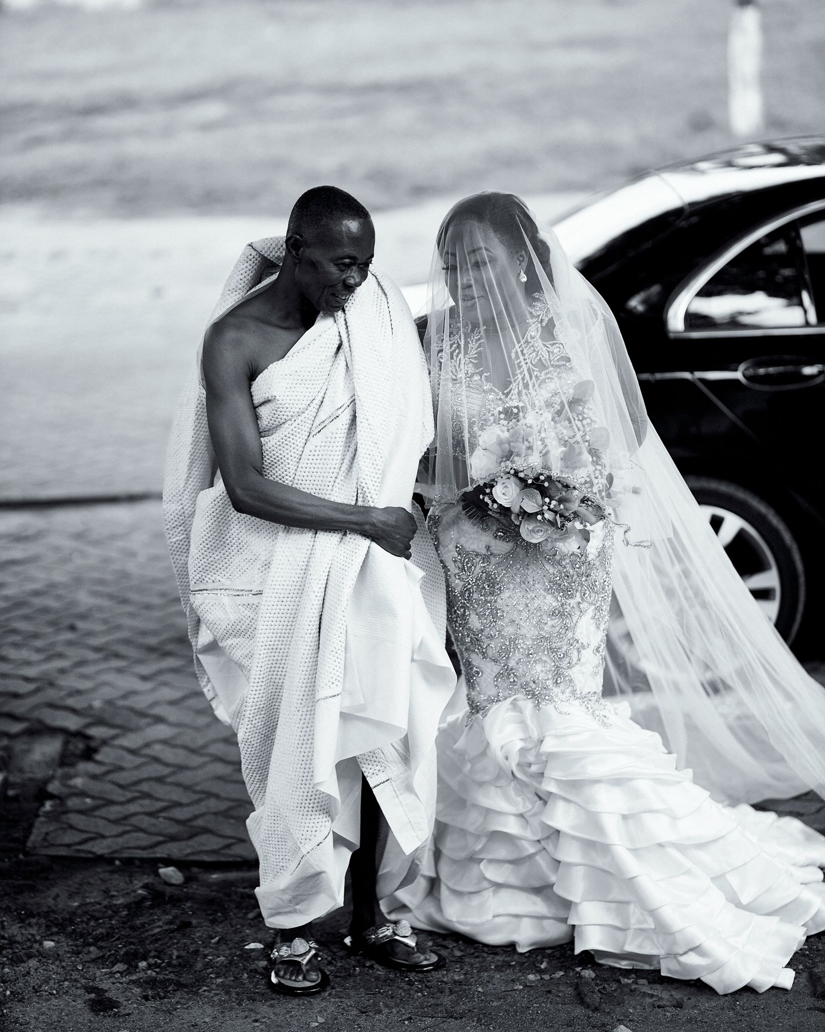 A romantic black and white wedding photo with flowing veil and elegant attire.