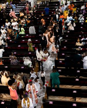 Wedding ceremony in a large church with guests seated in wooden pews.