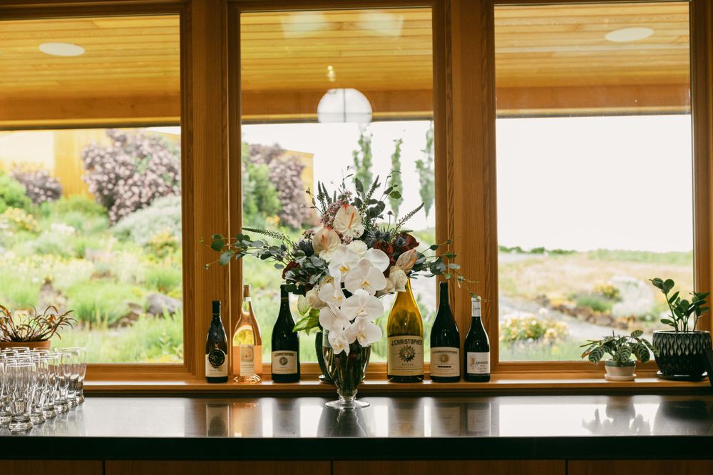 Row of windows with decorative vases and bottles creating a bright, airy display.