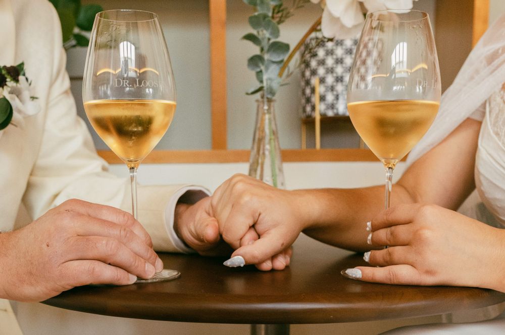 Wine glasses filled with white wine on a wooden table during a tasting.