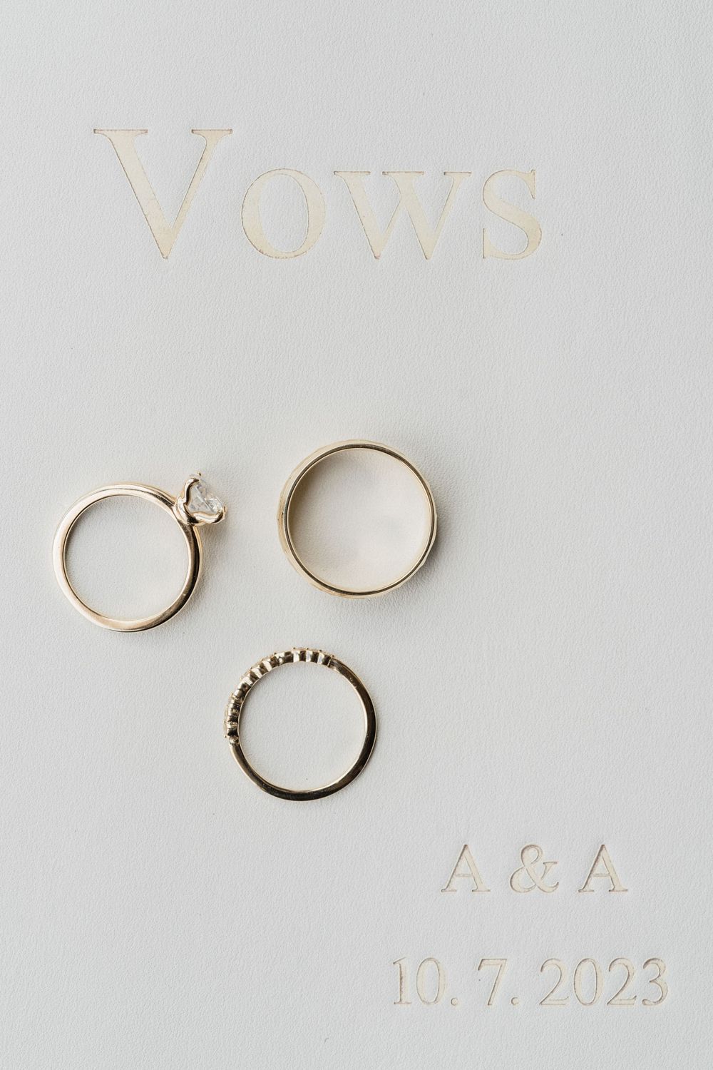 Gold wedding rings arranged artistically on a light gray background.