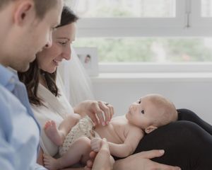 Sweet interactive family moments captured by window in bright room.