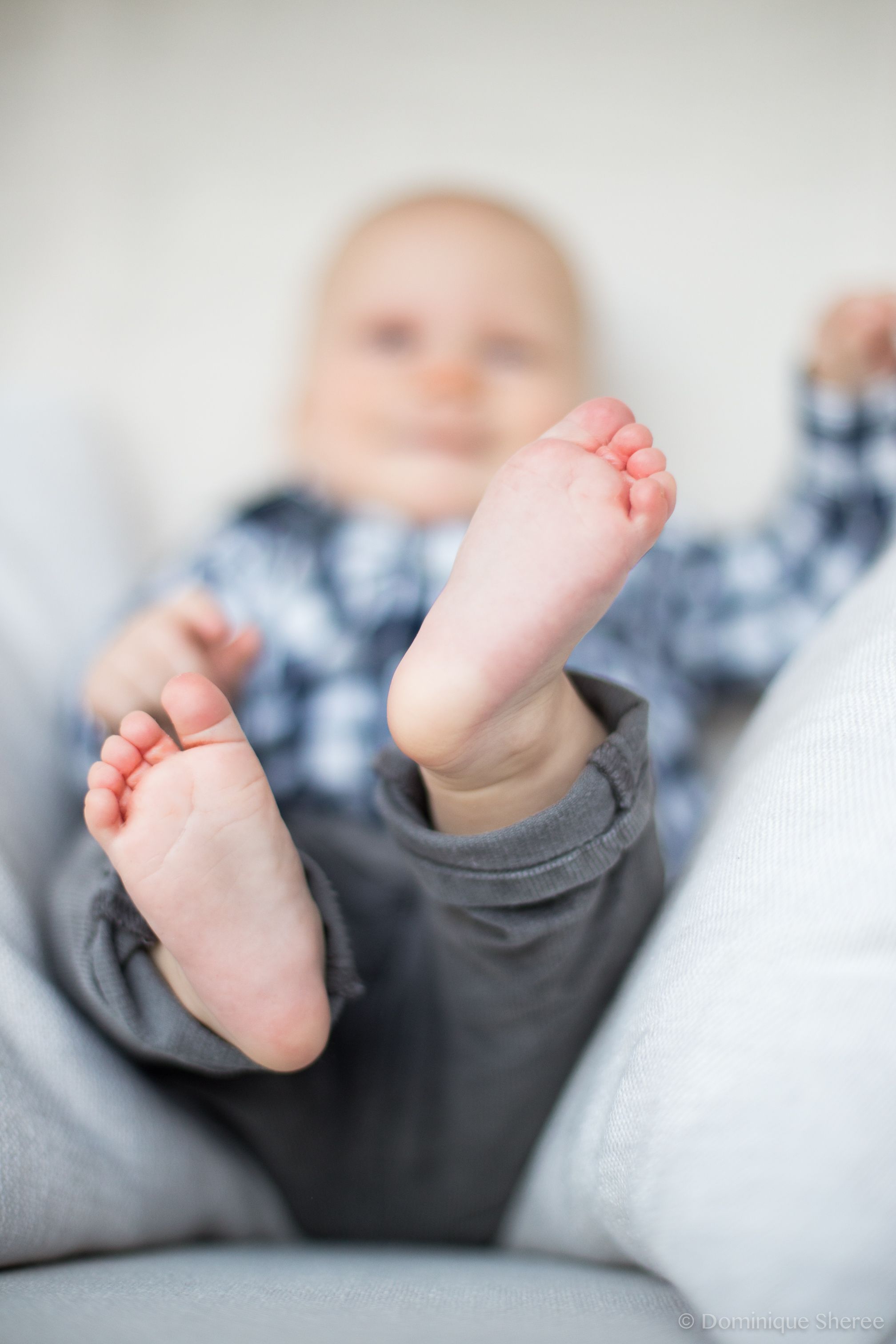Close up of tiny baby feet against blurred background.