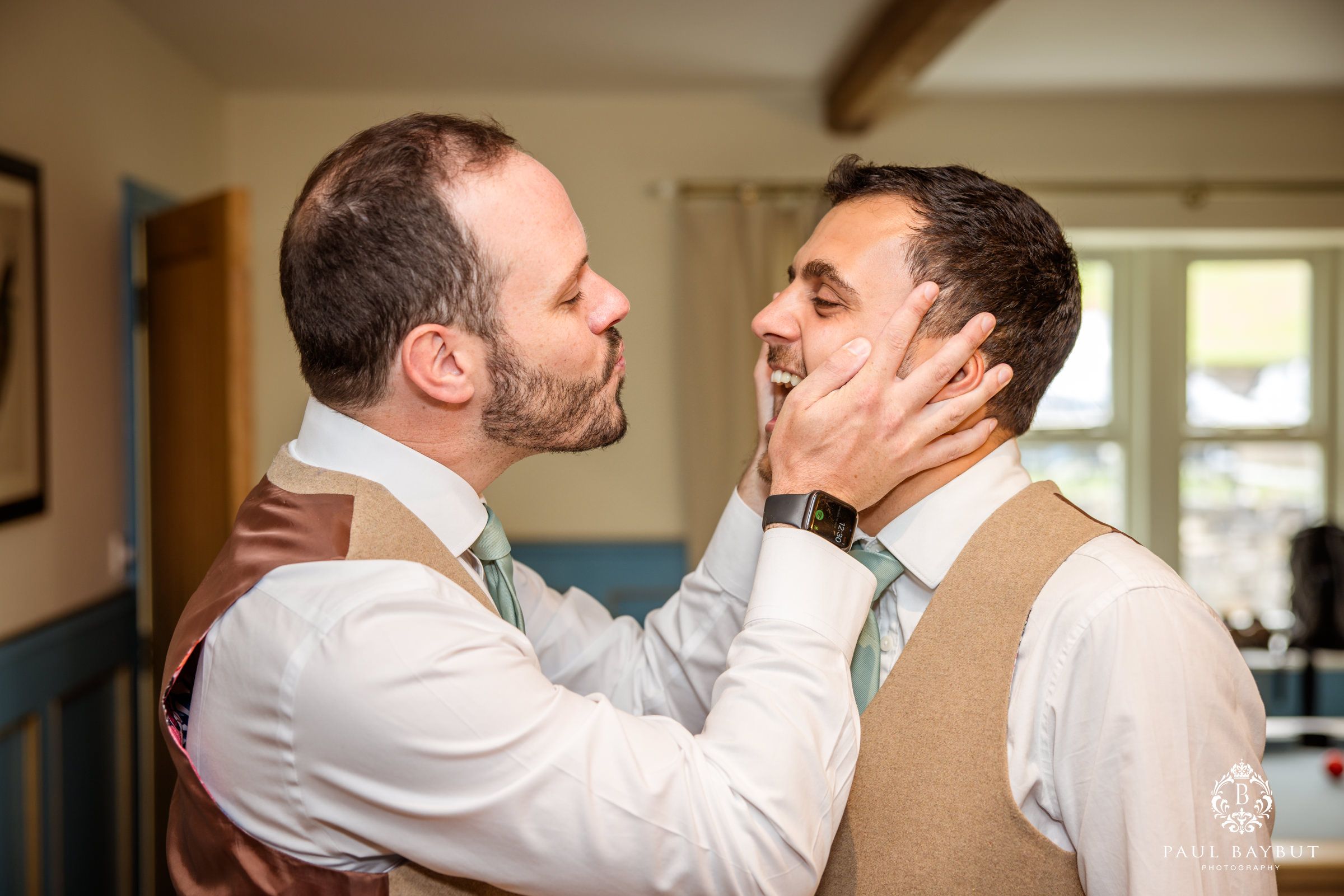 Emotional moment shared between two people in formal attire during wedding preparations.